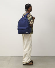 CANVAS BACKPACK Accessories in navy cotton canvas with white Stüssy logo, on-body side view. | product-card-slider