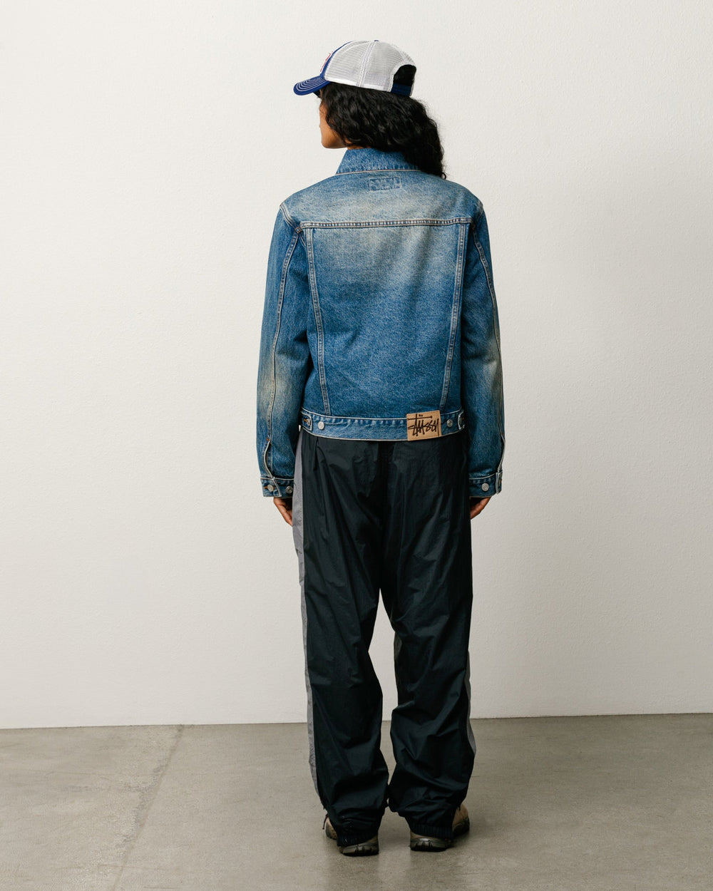 Stüssy unisex denim trucker jacket in dark wash indigo, back view